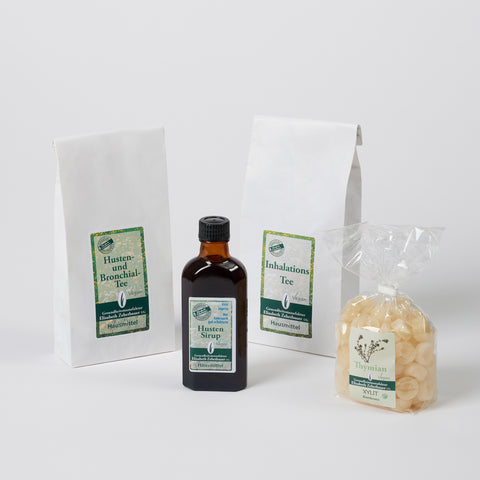 Das Set besteht aus einer Tüte Husten und Bronchialtee eine Flasche Husten Sirup eine Tee Tüte Inhalationstee und ein gpßer durchsichtiger Beutel mit Thymianbonbons. Produktbild
