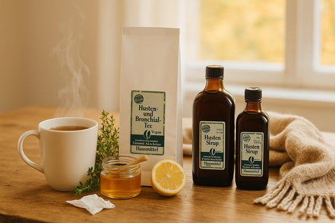 2 Flaschen Husten Sirup, Husten und Bronchial-Tee auf einem Tisch mit  einer heißen Tasse Tee, Honig und Zitrone