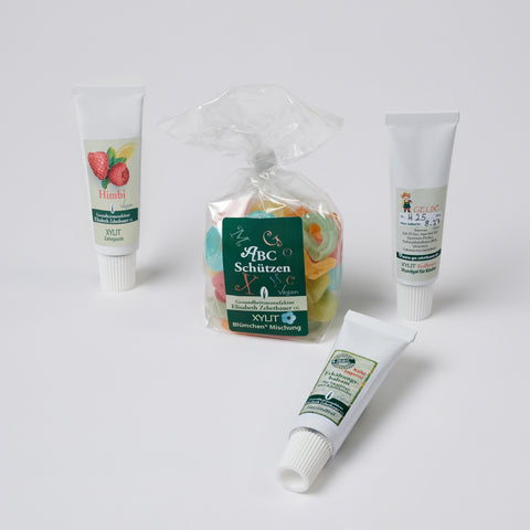 Eine 20 g Tube Himbeer Zahnpasta eine 90 g Packung ABC SchützenMischung eine Tube 20 g Gelix - Xyligel Erdbeergeschmack eine Tube 20 g Erkältungsbalsam für Säuglinge und Kinder. Produktbild
